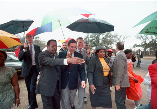 1988: Gretna Mayor Wallace, left center, guides Florida Governor Bob Martinez and Insurance Commissioner Bill Gunter, center, and Anita Davis, local branch president of the NAACP, right, as they lead a mile-long Martin Luther King Jr. Commemorative Celebration march on a rainy Monday afternoon in Gretna, Florida.