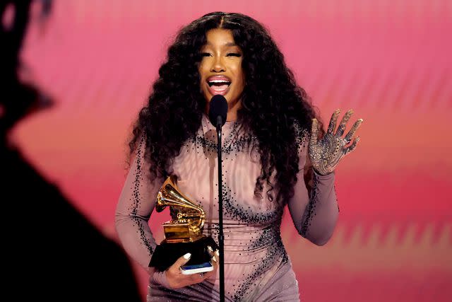 <p>Kevin Winter/Getty</p> SZA takes home best R&B song for "Snooze" in sheer dress at the 2024 Grammys