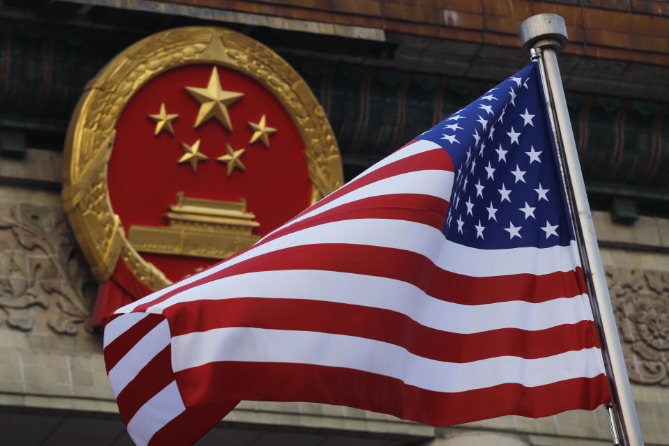 En esta imagen de archivo, una bandera estadounidense ondea junto al emblema nacional chino durante una ceremonia de bienvenida en el Gran Salón del Pueblo, en Beijing, el 9 de noviembre de 2017. (AP Foto/Andy Wong, archivo)