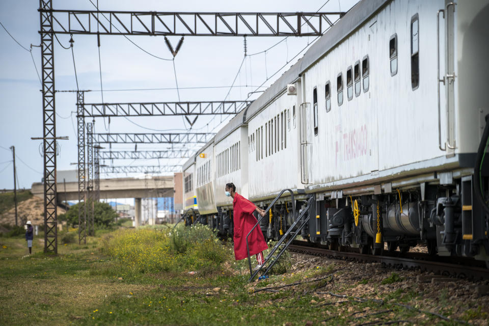 An employee walks down from a COVID-19 vaccination train parked at the Swartkops railroad yard outside Gqeberha, South Africa, Thursday Sept. 23, 2021. South Africa has sent a train carrying COVID-19 vaccines into one of its poorest provinces to get doses to areas where healthcare facilities are stretched. The vaccine train, named Transvaco, will go on a three-month tour through the Eastern Cape province and stop at seven stations for two weeks at a time to vaccinate people. (AP Photo/Jerome Delay)