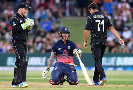 Cricket - ODI - New Zealand vs England - Bay Oval, Tauranga, New Zealand, February 28, 2018. England's Ben Stokes goes down on his knees as New Zealand's Tom Latham and Colin de Grandhomme react during their one-day international match. REUTERS/Ross Setford