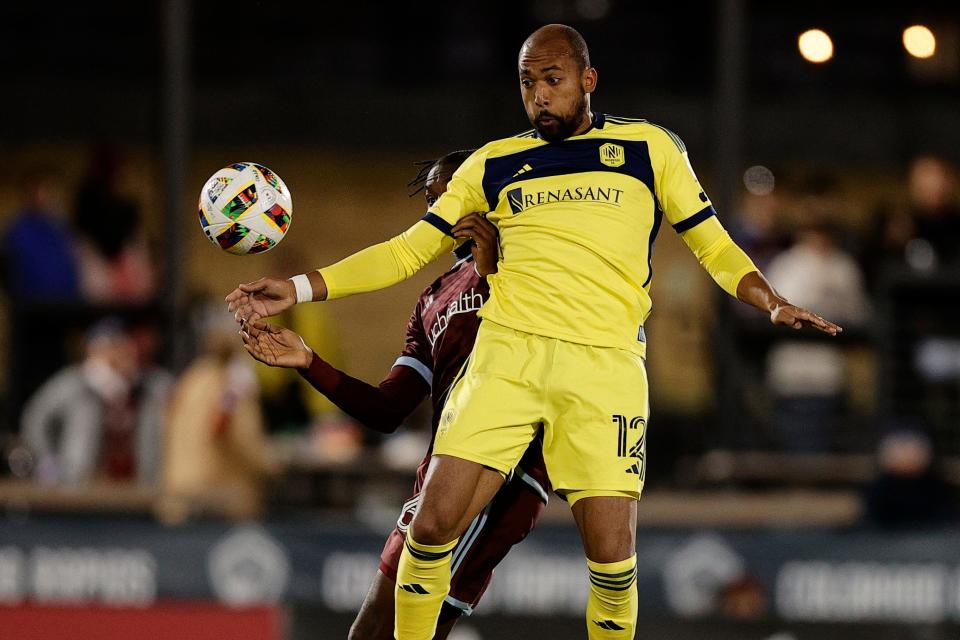 Mar 2, 2024; Commerce City, Colorado, USA; Nashville SC forward Teal Bunbury (12) battles for a header against Colorado Rapids defender Moise Bombito (64) during the second half at DickÕs Sporting Goods Park. Mandatory Credit: Isaiah J. Downing-USA TODAY Sports