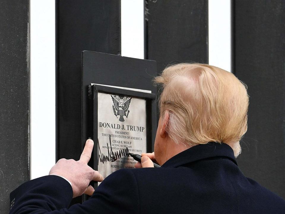 The president signs a plaque on the wall yesterday (AFP)