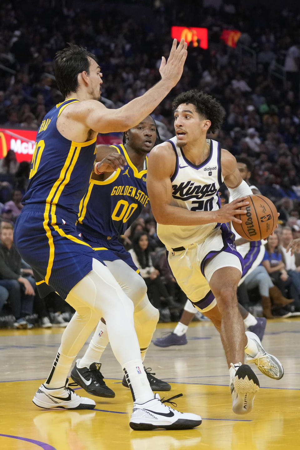 Sacramento Kings guard Colby Jones, right, drives to the basket against Golden State Warriors forward Dario Saric, left, and forward Jonathan Kuminga (00) during the first half of an NBA basketball game in San Francisco, Wednesday, Nov. 1, 2023. (AP Photo/Jeff Chiu)
