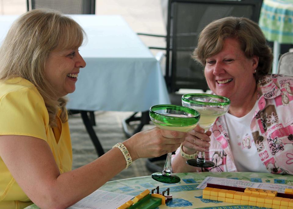 This May 31, 2013 photo shows Benita Munger, left, and Judy Palladino toasting during a game night gathering in Mayfield Village, Ohio. For the baby boomer generation, getting together to play games is a way to stay active and social. It also can help people stay mentally sharp. (AP Photo/Bonnie Gruttadauria)