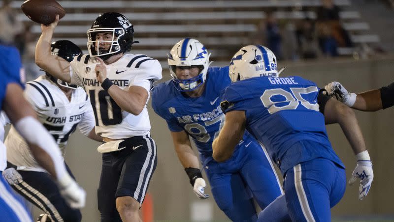 Air Force defensive lineman Caden Blum (87) and defensive end Daniel Grobe (95) pressure Utah State quarterback McCae Hillstead (10) during the second half of an NCAA college football game in Air Force Academy, Colo., Friday, Sept. 15, 2023. 