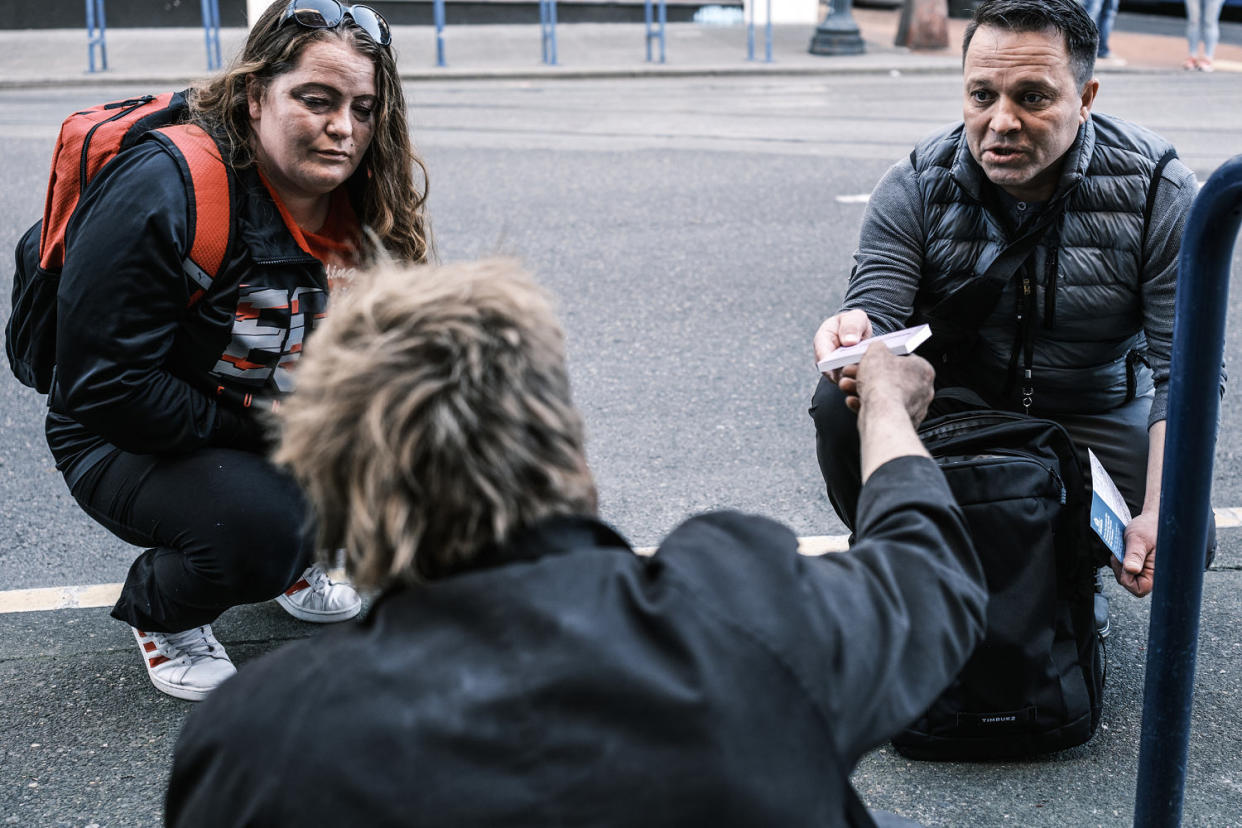 Mary Mcabee and Ricco Mejia speak with an individual about accessing substance abuse resources (Jordan Gale for NBC News)