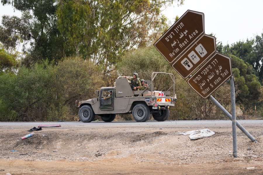 Israeli soldiers drive by the rave party site, where scores were killed, near the Kibbutz Re’im, close to the Gaza Strip border fence, on Tuesday, Oct.10, 2023. Israel’s rescue service Zaka said paramedics had recovered at least 260 bodies of people attending the party who were killed in a surprise attack by Hamas militants Saturday. (AP Photo/Ohad Zwigenberg)