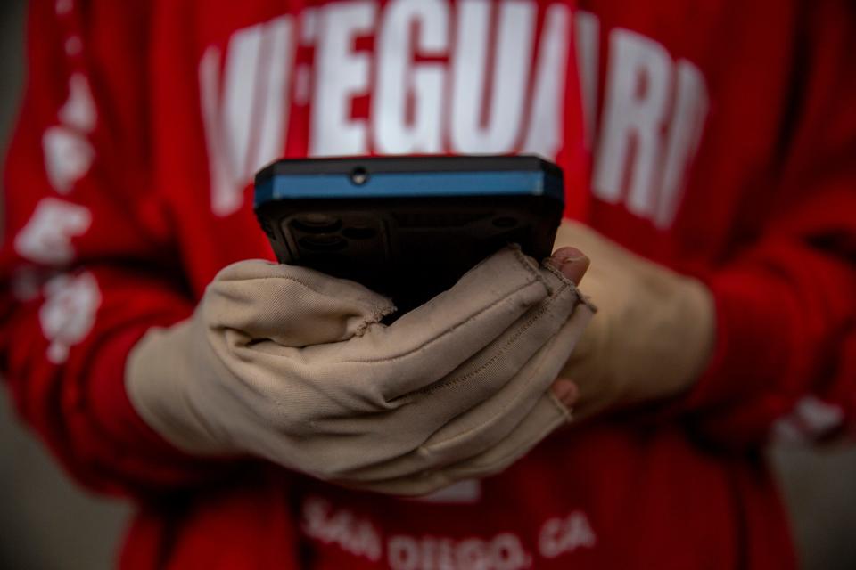 Diego Suy Guarchaj clutches his cell phone outside his home in Guatemala seven months after he was rescued from a burning migrant detention center in Juárez. He was hospitalized with burn injuries when he used his phone to learn his friends died in the inferno.