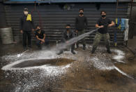 Employees of the Lavakar car wash pose for a group portrait in Mexico City, Friday, July 31, 2020. The workers said the shop was closed for three months during the COVID-19 related lockdown, and now after reopening only wash about 10 cars a day, compared to 30 before the lockdown. (AP Photo/Marco Ugarte)