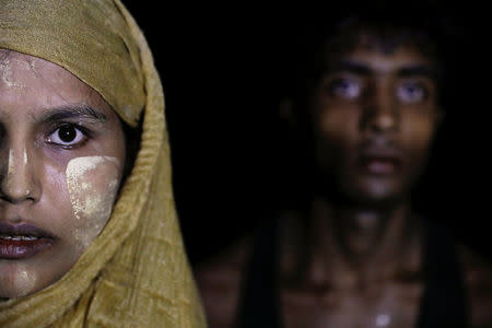 A woman makes her way to the shore as hundreds of Rohingya refugees arrive under the cover of darkness by wooden boats from Myanmar to Shah Porir Dwip, in Teknaf, near Cox's Bazar in Bangladesh, September 27, 2017. REUTERS/Damir Sagolj