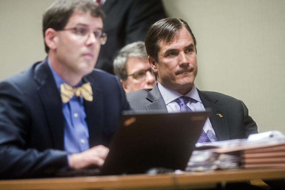 Nick Lyon, right, director of the Michigan Department of Health and Human Services, listens closely as Genesee District Judge David J. Goggins gives his decision during Lyon's preliminary examination on Monday, Aug. 20, 2018 at Genesee District Court in Flint, Mich. Goggins ordered Lyons to stand trial for involuntary manslaughter in two deaths linked to Legionnaires' disease in the Flint area, the highest ranking official to stand trial as a result of the tainted water scandal. (Jake May/The Flint Journal via AP)