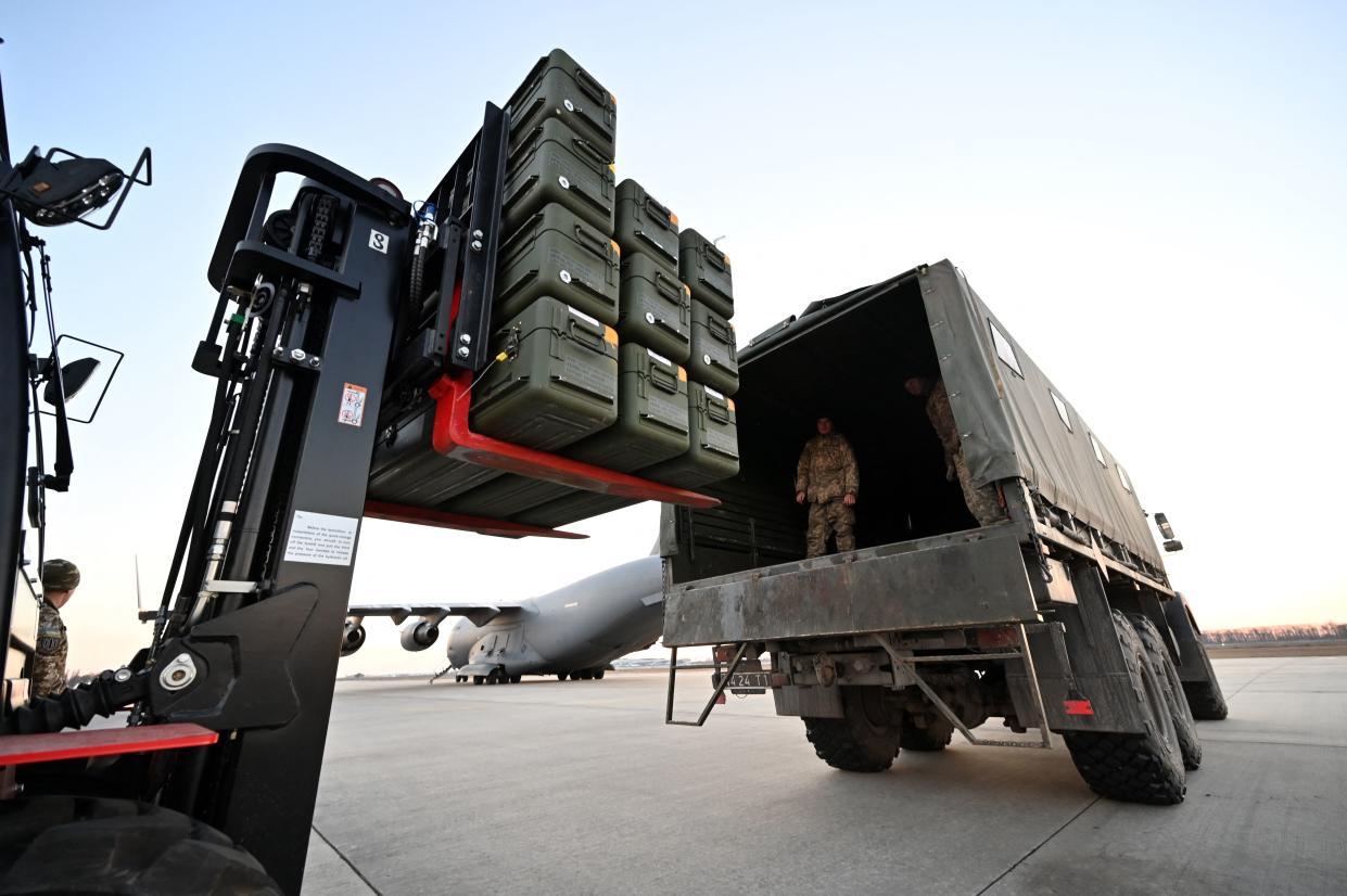 Ukrainian servicemen move U.S.-made FIM-92 Stinger missiles and other military items off a truck at an airport in Kyiv.