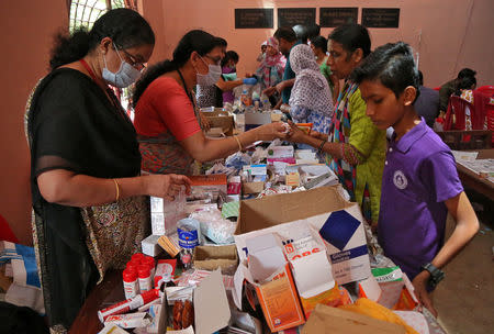 Flood-affected people receive free medicines inside a college, which has been converted into a temporary relief camp, in Aluva in the southern state of Kerala, India, August 20, 2018. REUTERS/Sivaram V