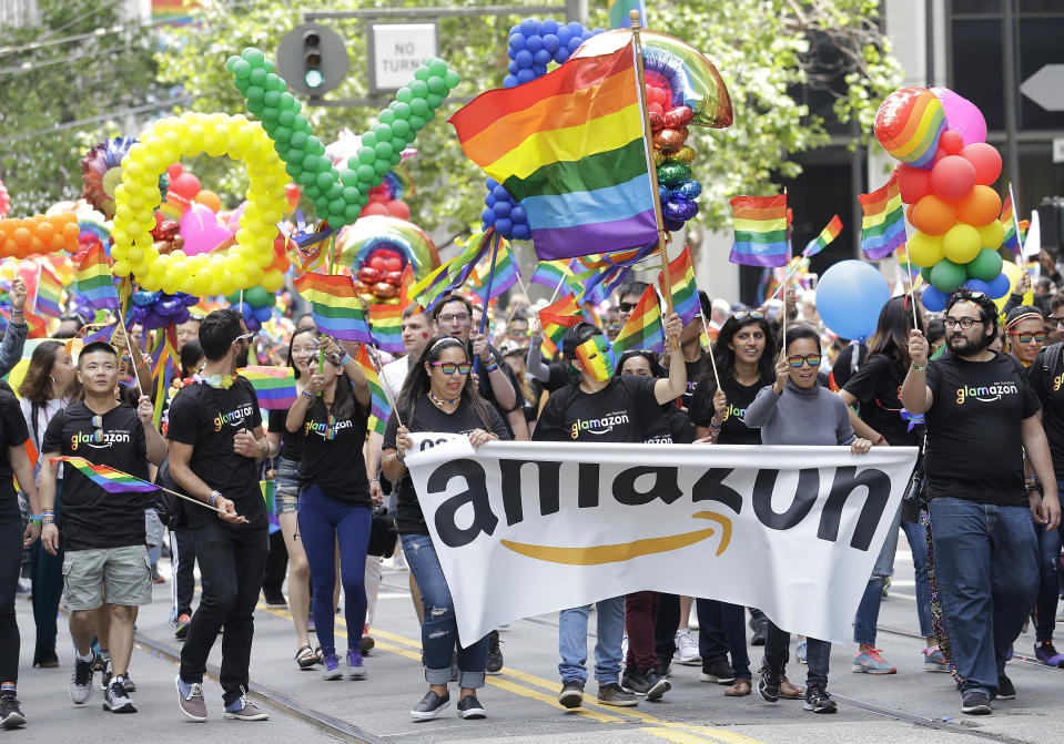 FILE - In this June 25, 2017 file photo, a group with Amazon marches in the Pride parade in San Francisco. More than 400 companies, including Amazon, have signed on to support civil rights legislation for LGBTQ people that is moving through Congress, advocates said Tuesday, April 27, 2021. The Equality Act would amend existing civil rights law to explicitly include sexual orientation and gender identification as protected characteristics. (AP Photo/Jeff Chiu, File)