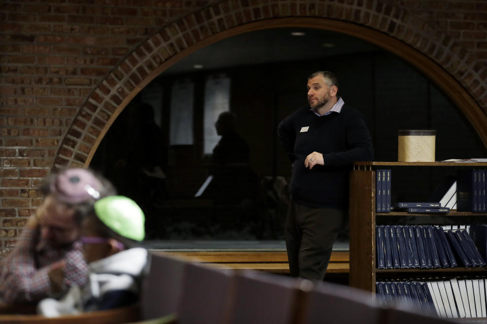 In this Jan. 17, 2020, photo Andy Kirschner, right, listens to Rev. Dr. Maurice Charles, dean of Rockefeller Memorial Chapel, during the Friday Shabbat Service at KAM Isaiah Israel in Chicago. On the eve of the day set aside to honor an African American who strove against hate and preached racial and social justice, some worry the nation is becoming more divided. (AP Photo/Nam Y. Huh)