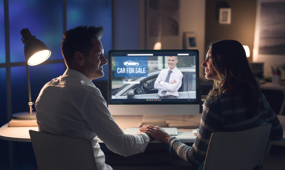 Man and woman looking at car buying options online.