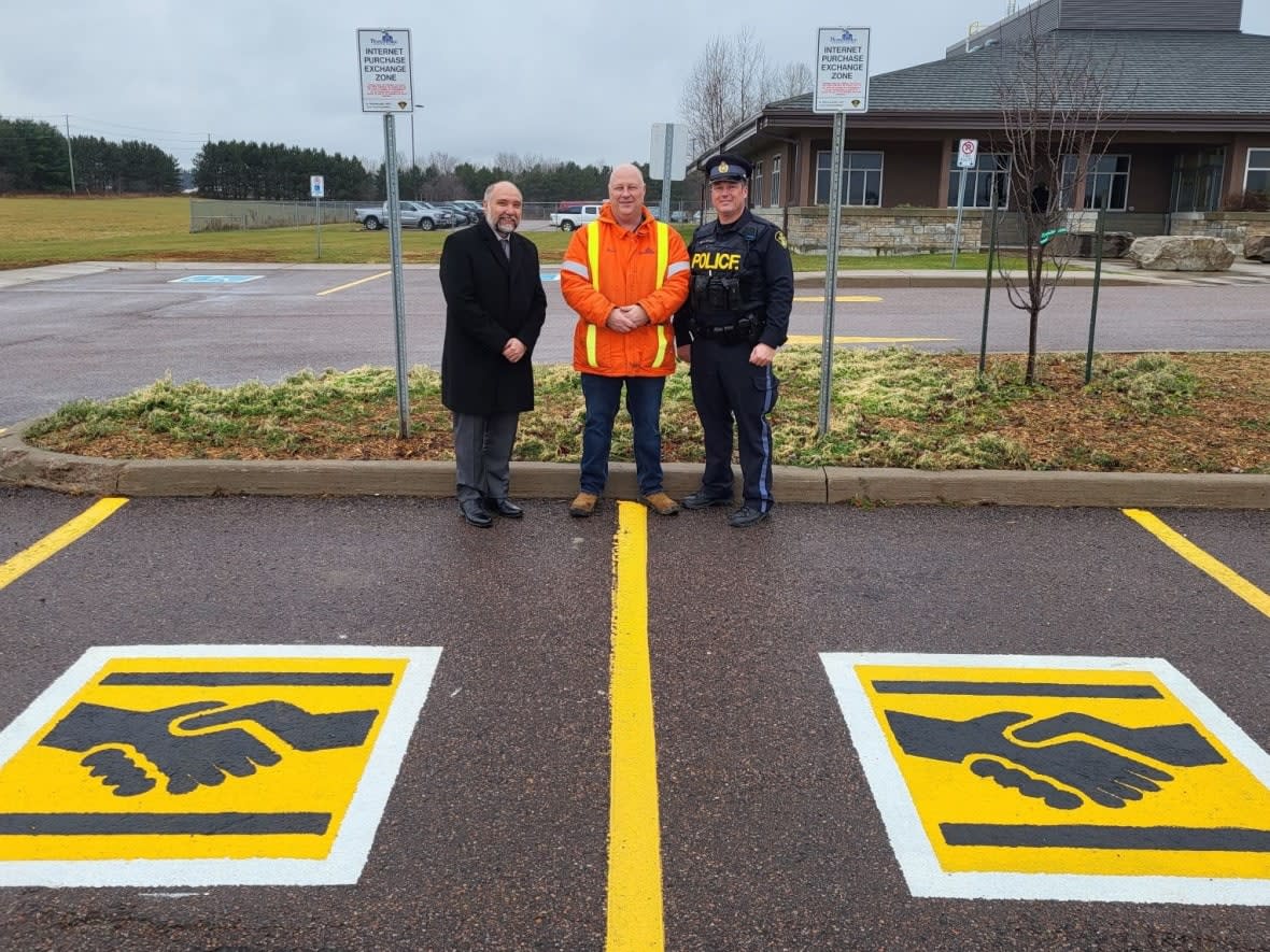 From left to right, Pembroke Mayor Ron Gervais, the city's roads and fleet supervisor Brad Faught and Upper Ottawa Valley OPP Const. Darryl Graveline show off the designated 'safe trade' zone at the Pembroke OPP detatchment on International Drive.    (Upper Ottawa Valley OPP - image credit)