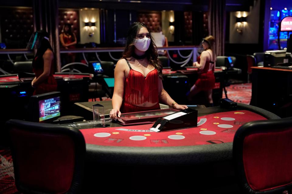 A dealer wearing a protective face mask waits for customers before the reopening of the D Las Vegas hotel and casino, June 3. Casinos and other businesses are navigating best practices to protect employees and customers from the spread of the coronavirus.