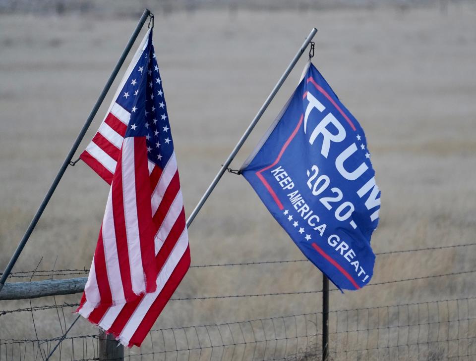 An American and Trump 2020 flag wave in the evening wind outside Gillette, Wyoming, a small city with some of former President Donald Trump's most ardent supporters.