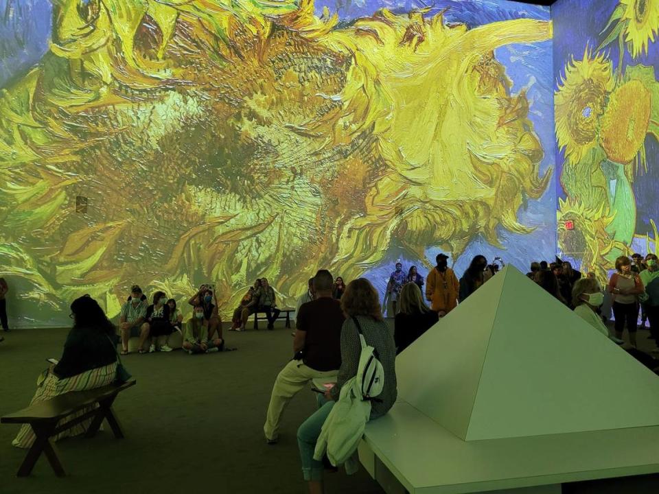 Visitors watch digital renditions of Vincent Van Gogh’s sunflower series at “Van Gogh: The Immersive Experience” at the Olympia Theater.