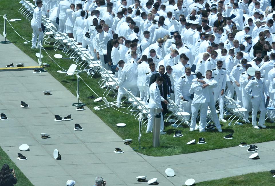 Hugs amongst a sea of tossed caps as the cadets head out to greet family and friends at the Massachusetts Maritime Academy Commencement last Saturday in Buzzards Bay. Steve Heaslip/Cape Cod Times