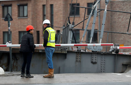 Workers inspect a Humbeek lift bridge, which was damaged when lowered onto a barge, blocking Brussels-Scheldt canal traffic, in Humbeek near Brussels, Belgium, January 17, 2019. REUTERS/Francois Lenoir