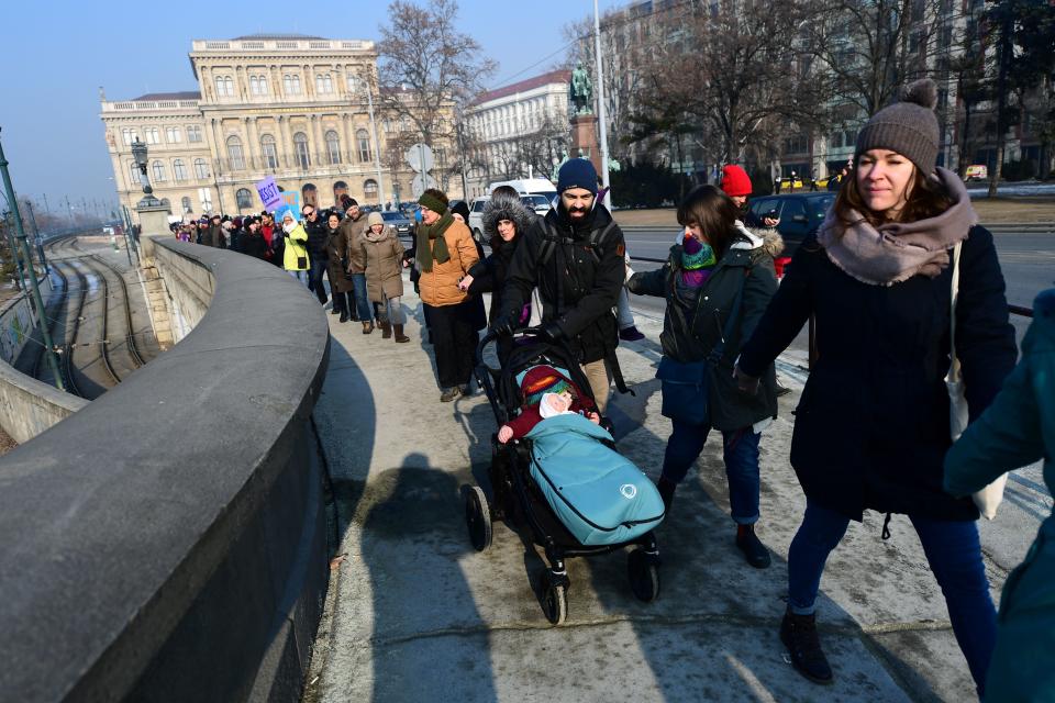 Participants create a human-chain and walk on Lanchid (Chain Bridge) in Budapest downtown on January 21, 2017 during a women protesters march in a rally against US President Donald Trump following his inauguration. A Women's March kicked off, the first of a series of global protests in defense&nbsp;of women's rights, as demonstrators rally against Donald Trump, who was sworn in as the 45th president of United States on January 20.&nbsp;