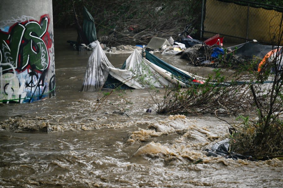Rising waters caused by heavy rain destroy encampments along the Santa Ana River near Van Buren Street in Riverside, Calif., on Monday, Feb. 5, 2024. (Anjali Sharif-Paul/The Orange County Register via AP)