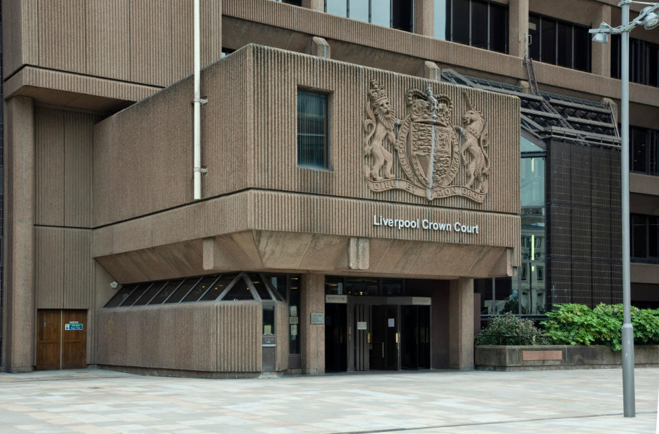 The outside of Liverpool Crown Court, a brown stone building with a crest engraved into its site