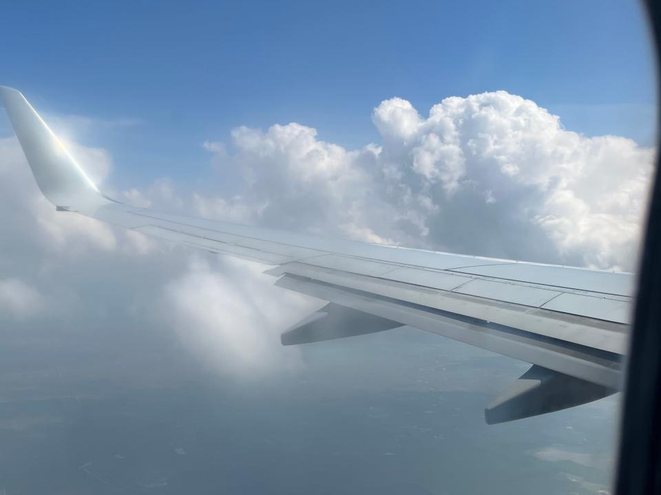 A plane's wing is shown in a cloudy sky in this photo, taken from a window of an American Airlines flight.