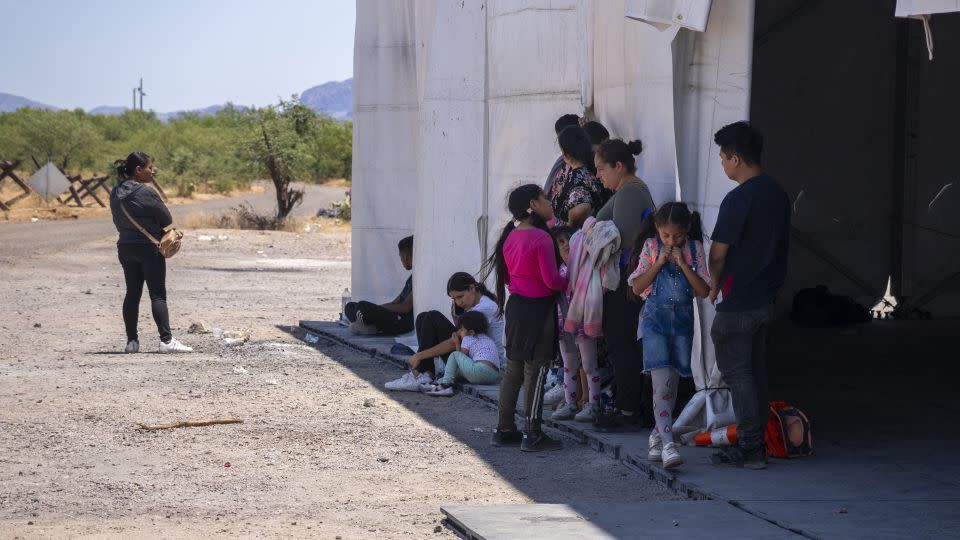 People wait to be taken in by Border Patrol after crossing the US-Mexico border near the San Miguel gate on the Tohono O'odham reservation, Arizona in June 2024. - Evelio Contreras/CNN