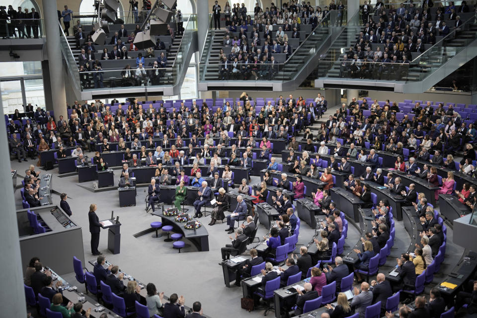 Britain's King Charles III and Camilla, the Queen Consort, center, listen to President of the Bundestag, Germany's Parliament, Baerbel Bas, standing at left, in the Bundestag in Berlin, Thursday, March 30, 2023. King Charles III arrived Wednesday for a three-day official visit to Germany. (AP Photo/Markus Schreiber)