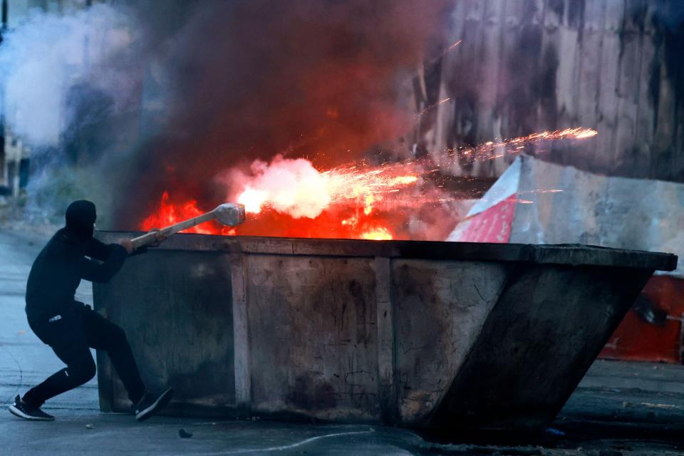 A Palestinian protester aims flares at Israeli troops amid clashes in Ramallah in the occupied West Bank on October 9, 2023. Palestinians in the occupied West Bank have rallied in support and clashed with Israeli security forces, leaving 15 Palestinians dead since October 7, as fighting raged between Israel and Hamas around the Gaza Strip.