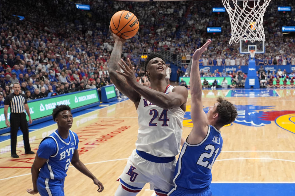 Kansas forward K.J. Adams Jr. (24) shoots over BYU guard Trevin Knell (21) during the first half of an NCAA college basketball game Tuesday, Feb. 27, 2024, in Lawrence, Kan. (AP Photo/Charlie Riedel)