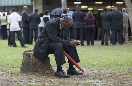 Eddie Bryan of North Charleston, South Carolina, rests on a stump outside the W.O.R.D. Ministry Christian Center in Summerville, South Carolina, April 11, 2015. REUTERS/Randall Hill