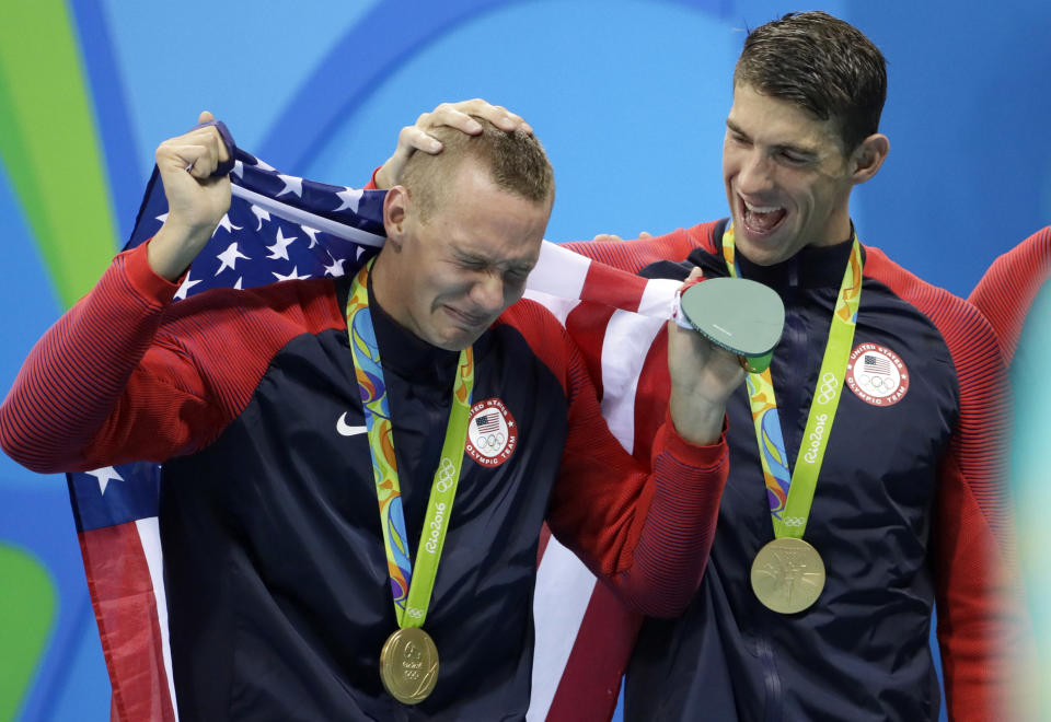 FILE - In this Aug. 8, 2016, file photo, Caeleb Dressel, left, cries with Michael Phelps after the medal ceremony for the men's 4x100-meter freestyle relay during the swimming competitions at the 2016 Summer Olympics, in Rio de Janeiro, Brazil. At two years to the day the Tokyo Olympics open, Katie Ledecky is swimming as fast as ever, Caeleb Dressel is being heralded as a potential Phelps, and Missy Franklin is attempting a comeback. And Ryan Lochte is newly banned again.(AP Photo/David J. Phillip, File)