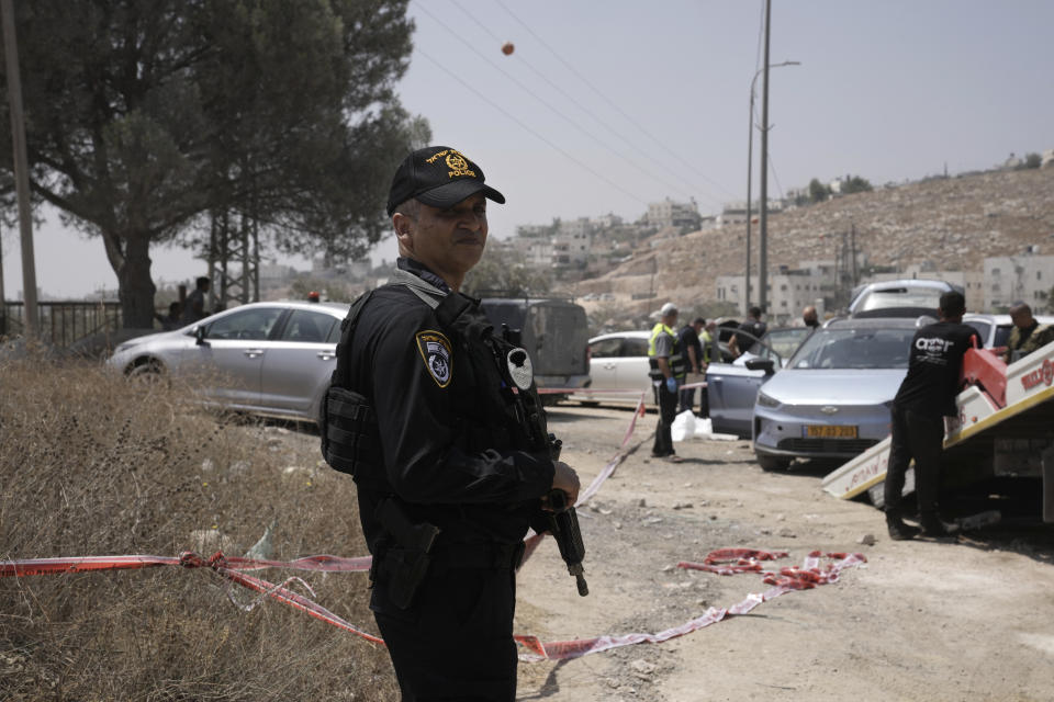 An Israeli police officer works at the site of a shooting attack near the West Bank city of Hebron, Monday, Aug. 21, 2023. Israeli authorities say that a suspected Palestinian attacker has killed an Israeli woman and seriously wounded a man in the incident. (AP Photo/Mahmoud Illean)