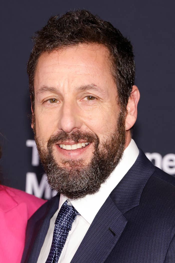 Close-up of Adam in a suit and tie at a media event