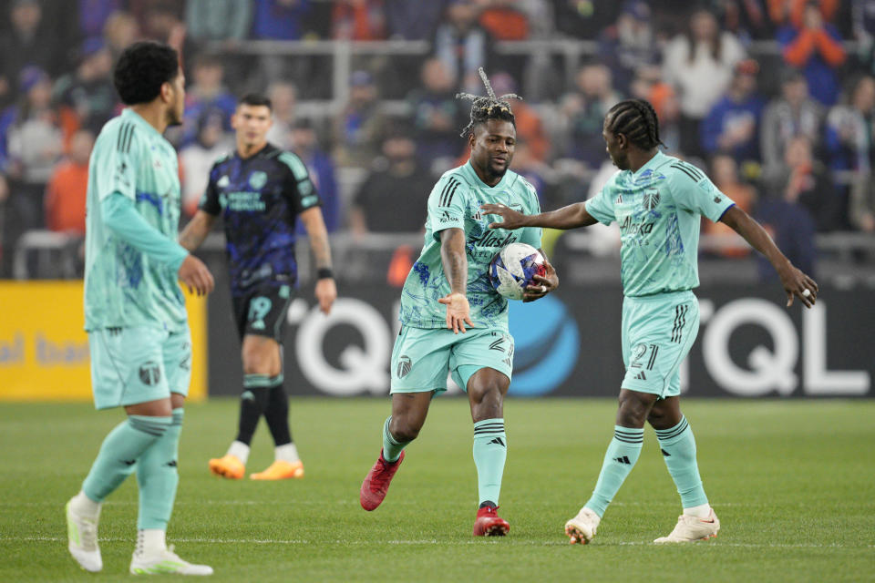 Portland Timbers' Dairon Asprilla (27) celebrates with Diego Chará (21) after scoring a goal during the second half of an MLS soccer match against FC Cincinnati Saturday, April 22, 2023, in Cincinnati. (AP Photo/Jeff Dean)