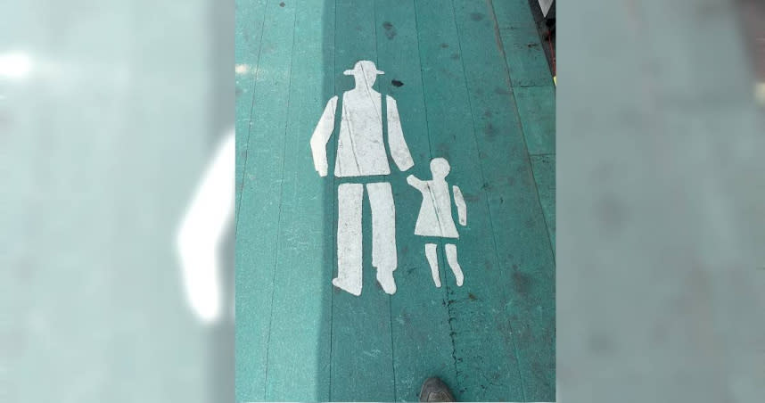 有網友拍下綠色人行道上，父親牽著小孩的白色路標圖，並在臉書社團發文寫下：「懂的都懂」。（圖／翻攝自臉書／《爆廢公社二館》）