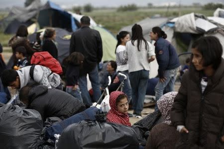 A refugee family sit in front of their tent waiting to be transferred to hospitality centres, during a police operation at a refugee camp at the border between Greece and Macedonia (FYROM), near the village of Idomeni, Greece, 24 May 2016. REUTERS/Yannis Kolesidis/Pool