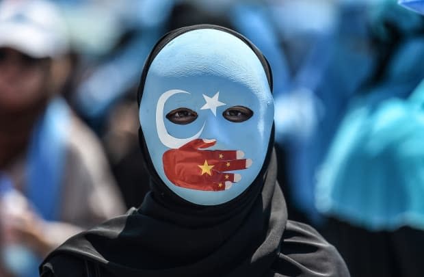 A masked demonstrator attends a protest denouncing China's treatment of Uyghur Muslims in front of the Chinese consulate in Istanbul, on July 5, 2018. Canadian senators on Tuesday voted down a motion to label China's treatment of the Uyghurs as a genocide. (Ozan Kose/AFP/Getty Images - image credit)