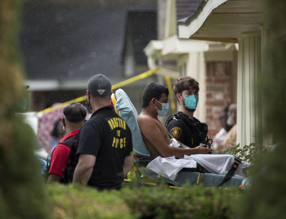 Paramedics transport a man into an ambulance from the scene of a human smuggling case, where more than 90 undocumented immigrants were found inside a home on the 12200 block of Chessington Drive, Friday, April 30, 2021, in Houston. A Houston Police official said the case will be handled by federal authorities and that some of the people inside the house were exhibiting COVID-19 symptoms. ( Godofredo A. Vásquez/Houston Chronicle via AP)