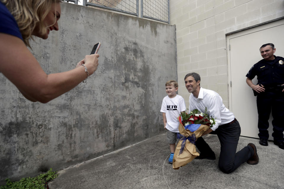 In this Tuesday, Oct. 2, 2018 photo, Jordan Flowers Maxwell, takes a photos of her son, Edison, posing for a photo with Democratic Senate candidate Rep. Beto O'Rourke during a campaign stop at Austin Community College Eastview, in Austin, Texas. O'Rourke has risen to national prominence on a workaday image that aligns closely with his politics but not his family's actual finances. (AP Photo/Eric Gay)