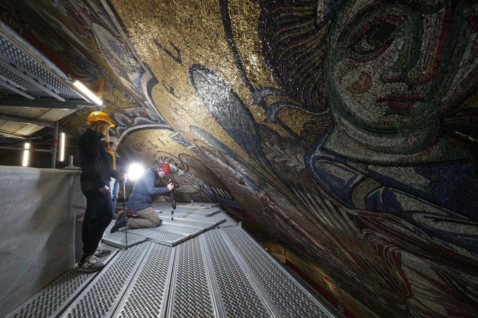 Technicians take photos during the restoration work of the mosaics that adorn the dome of one of the oldest churches in Florence, St. John's Baptistery, in Florence, central Italy, Tuesday Feb. 7, 2023. The restoration work will be done from an innovative scaffolding shaped like a giant mushroom that will stand for the next six years in the center of the church, and that will be open to visitors allowing them for the first and perhaps only time, to come come face to face with more than 1,000 square meters of precious mosaics covering the dome. (AP Photo/Andrew Medichini)