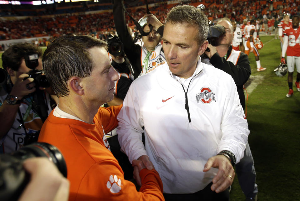 Ohio State head coach Urban Meyer, right, shakes hands with Clemson head coach Dabo Swinney after the Orange Bowl NCAA college football game, Saturday, Jan. 4, 2014, in Miami Gardens, Fla. Clemson defeated Ohio State 40-35. (AP Photo/Wilfredo Lee)