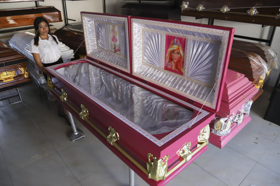 Ataúdes de color rosa con imágenes de la muñeca Barbie expuestos en una funeraria en Ahuachapán, El Salvador, el viernes 4 de agosto de 2023. Según el propietario del negocio, la idea ha sido un éxito y entendida como una forma alegre para despedir a un ser querido. (AP Foto/Salvador Meléndez)