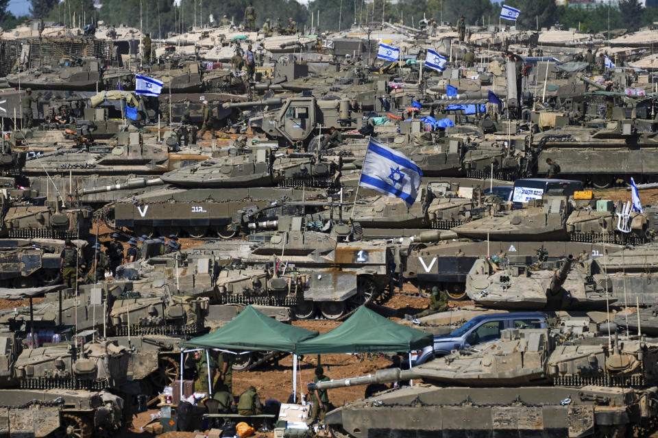 Israeli soldiers work on armored military vehicles at a staging ground near the Israeli-Gaza border, in southern Israel, Wednesday, May 8, 2024. (AP Photo/Tsafrir Abayov)