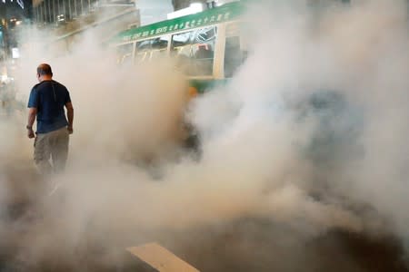 An anti-extradition bill protester is seen among the gas in Causeway Bay, Hong Kong